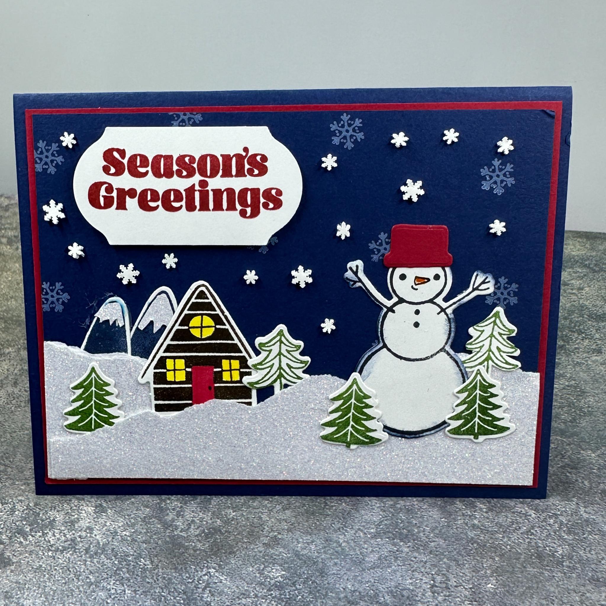 Sparkling Snowman Holiday Card with Cozy Home and Snowflake Accents