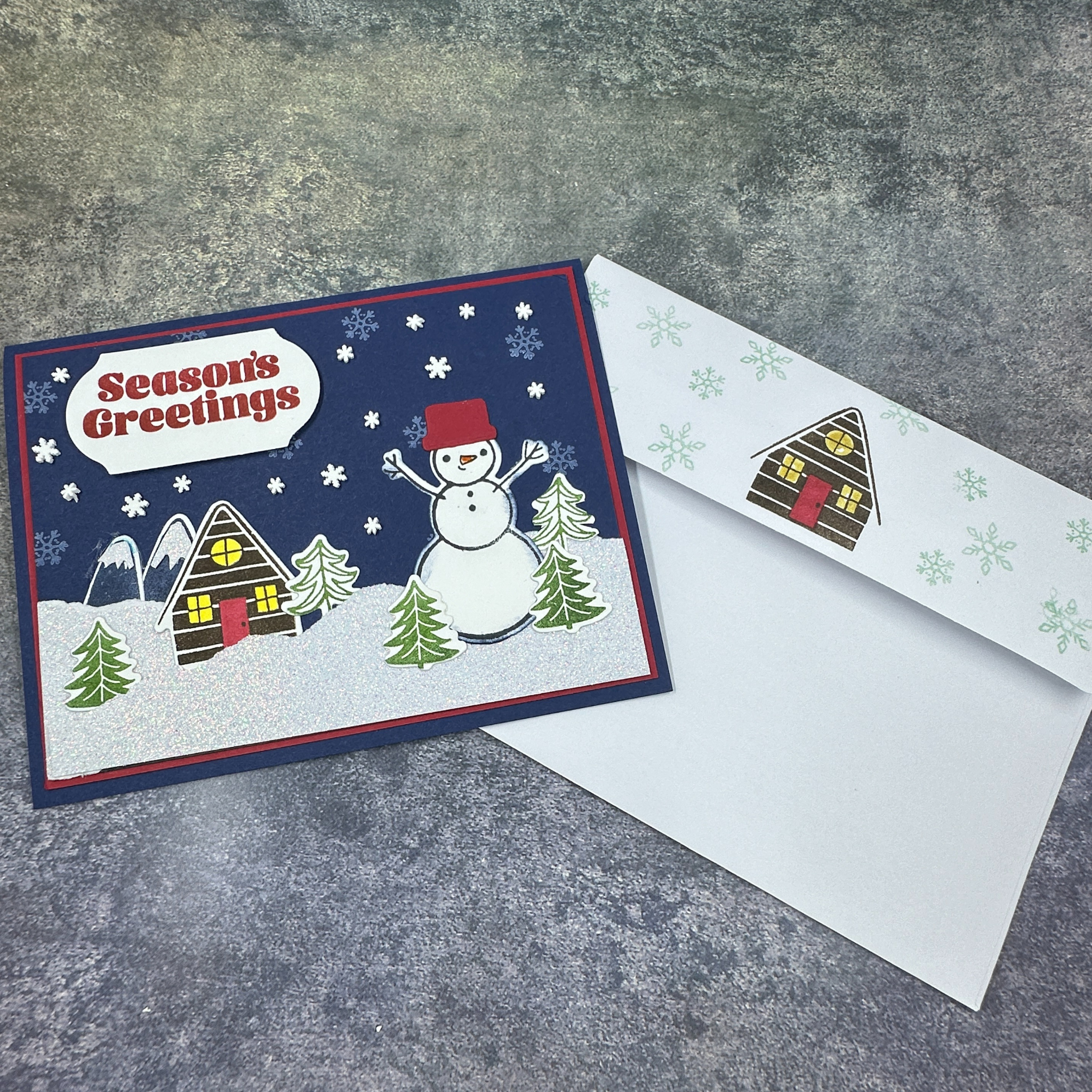 Sparkling Snowman Holiday Card with Cozy Home and Snowflake Accents